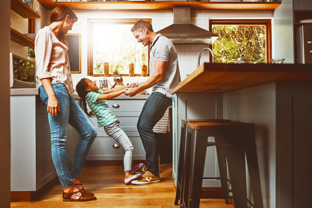 Parents and child playing in kitchen