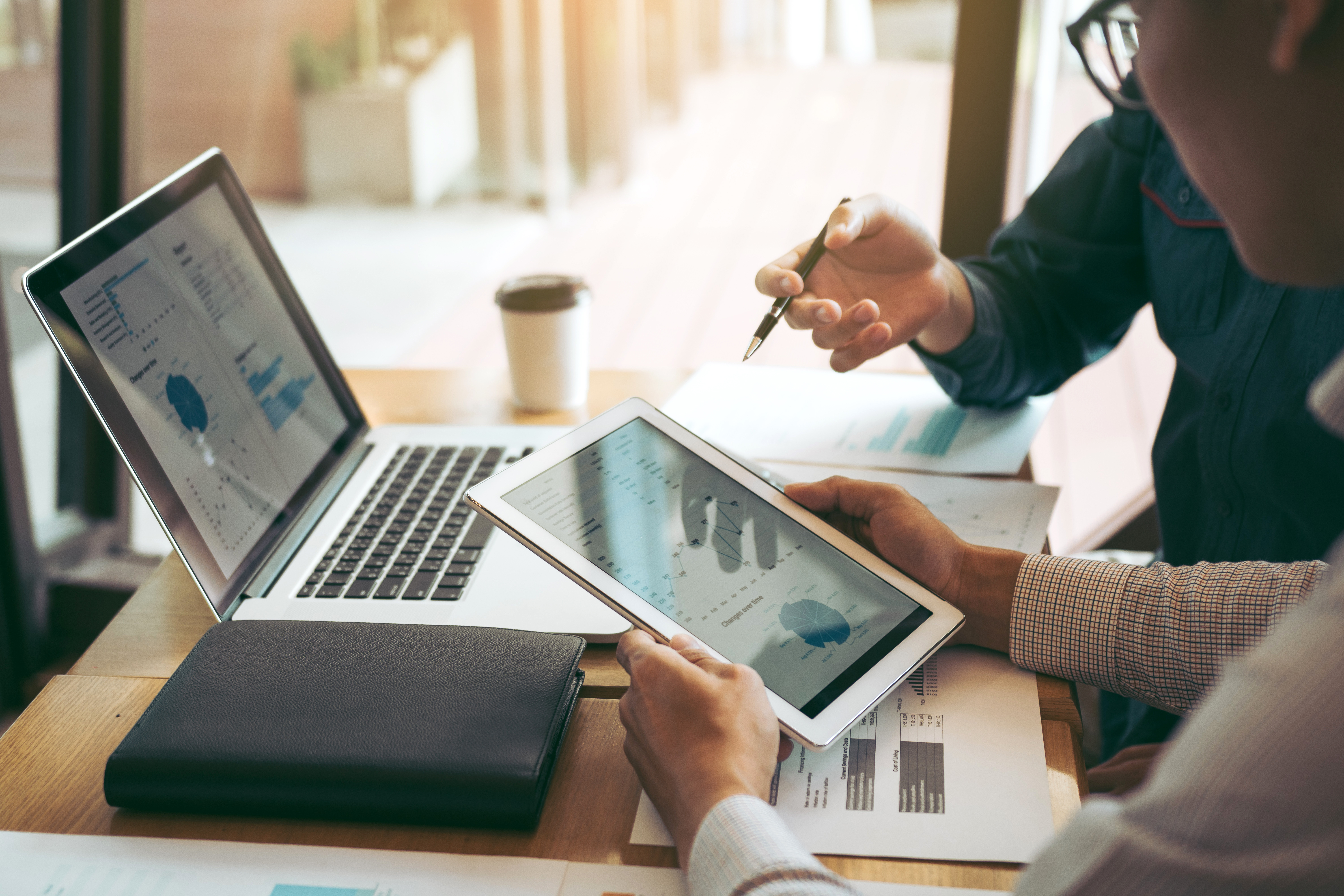 Collègues utilisant une tablette pour tracer le rapport des états financiers de l'entreprise et la planification dans la salle de bureau